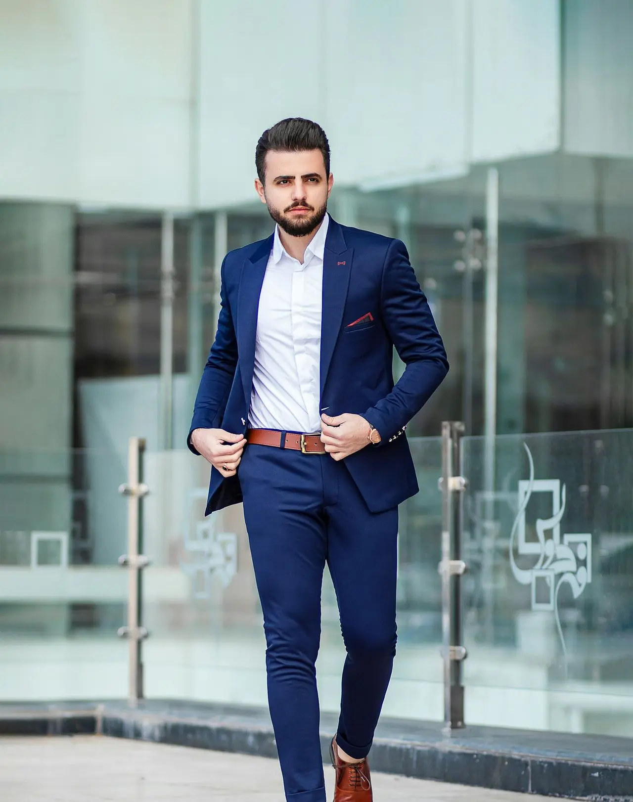 man in blue suit standing on sidewalk during daytime